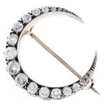 A Victorian diamond crescent brooch, with cushion shaped old cut diamonds, the largest weighing
