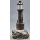 A Cornish serpentine table lamp in the form of a lighthouse, c1920, 48cm h Cylindrical glass shade