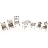 A Dutch miniature silver model of a table, a smaller model and five miniature silver chairs, table