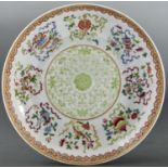 A Chinese famille rose saucer-dish, painted in green monochrome to the centre with tendrils bordered