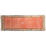 A reproduction woollen runner, the salmon pink field with stylised animal within sand coloured guard