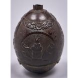 A brass mounted and carved coconut powder flask, early 19th c, with three roundels of birds at a