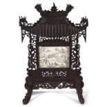 A Chinese carved and pierced wood pagoda shaped firescreen, c1900, inset with an ink and watercolour