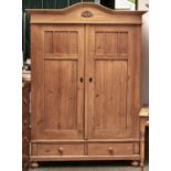 A Continental pine wardrobe, late 19th / early 20th c, with arched top enclosed by a pair of