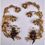 A pair of bronze and giltmetal three light wall sconces, of leafy naturalistic design curling to