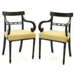 A pair of Regency mahogany scroll arm elbow chairs, c1820, the concave cresting rails inlaid with
