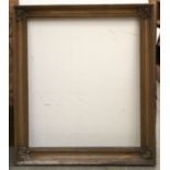 A Victorian giltwood and composition picture frame, with plain cavetto and volute leaf cornerpieces,