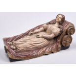 A Continental polychrome wood sculpture of a woman reclining on a draped couch, probably French,