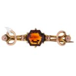 An hexagonal citrine bar brooch,  early 20th c, of looped gold wirework, 5.6g Pin slightly loose