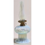 A bell shaped semi opalescent glass oil lamp, c1900, with German brass burner and matching glass