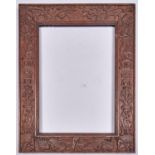 A Chinese carved wood frame, late 19th / early 20th c, with auspicious emblems and shou