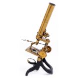 A brass compound microscope, the triangular limb on trunnions and focusing by rack work, the body