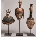 African Tribal Art. An Igbo wood mask, another mask and a helmet, 20th c, with white and other