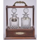 An Edwardian EPNS mounted oak tantalus and pair of cut glass decanters and stoppers, c1910, key,