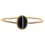 A gold bangle, mounted with earlier associated Victorian banded agate cabochon, 9.2g Good condition