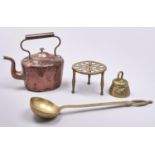 A Victorian copper kettle and cover, 21cm h, a brass culinary ladle, trivet and bell (4) Dents and