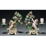 A pair of Bow 'Cupid catching a bird' bocage candlesticks, c1770, 22cm h, red enamel anchor and