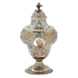 A George III silver tea caddy and cover, of pear shape, crisply chased with an eagle, flowers and