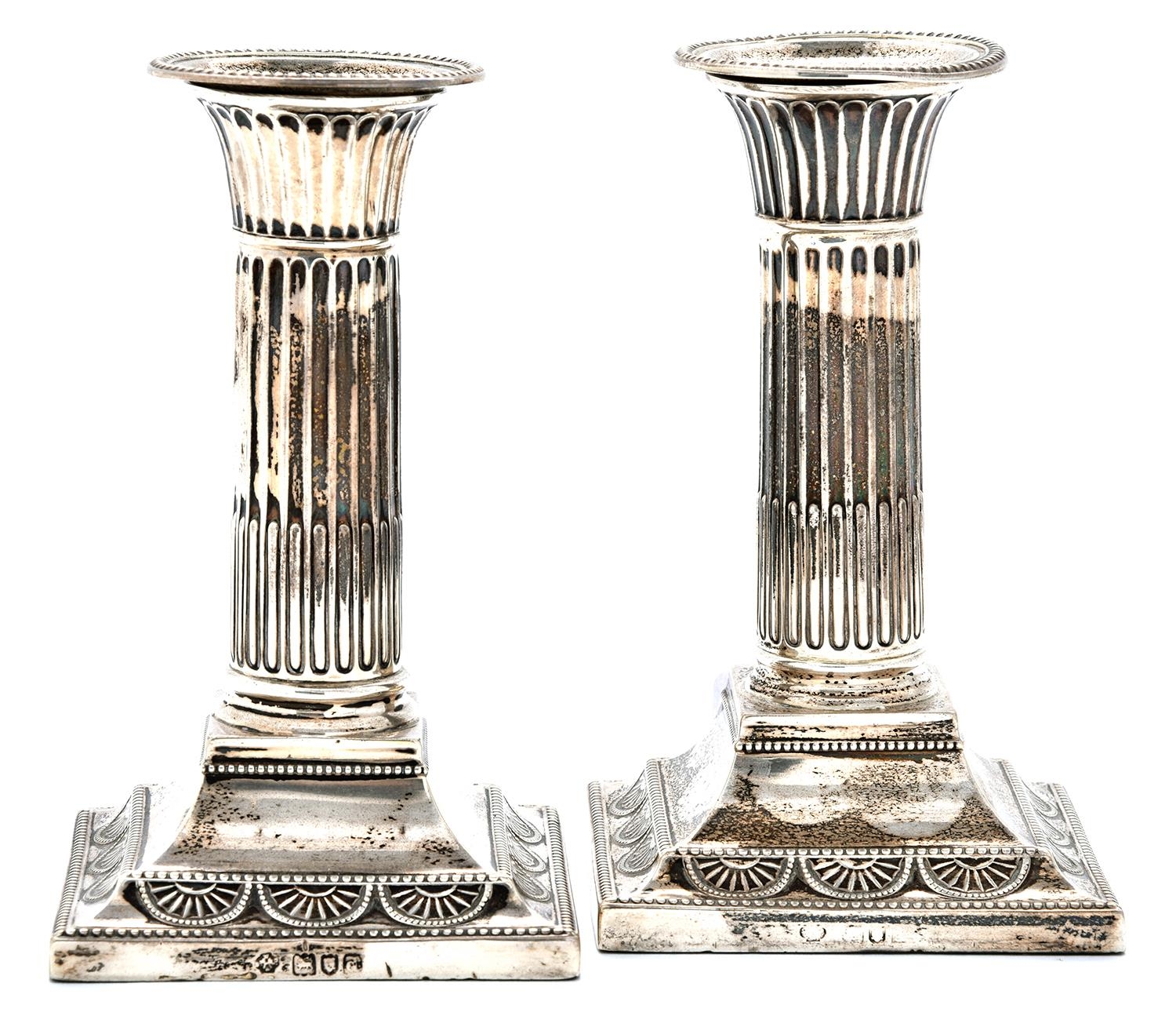 A pair of Victorian silver dwarf columnar candlesticks, with beaded nozzle and square foot, 13.5cm