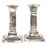 A pair of Victorian silver dwarf columnar candlesticks, with beaded nozzle and square foot, 13.5cm