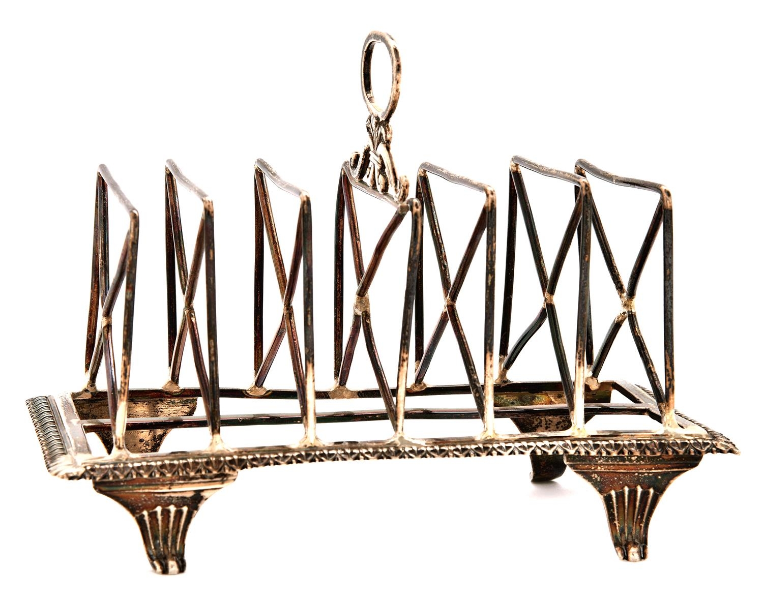A George III silver toast rack, with seven crossed wire divisions, rectangular base and reeded feet,