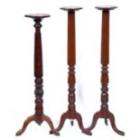 One and a pair of mahogany torcheres, mid 19th c, each incorporating a Victorian bedpost, 140 and