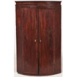 A George III bow fronted mahogany and line inlaid hanging corner cabinet, 69cm l Interior painted