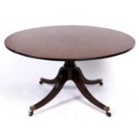 A mahogany breakfast table, 19th c, the line inlaid round tip-up table on turned pillar and