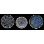 Two Turkish painted and glazed earthenware dishes, Kutahya, 20th c and a smaller slipware example,
