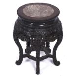 A Chinese hardwood stand, c1900, the pink stone inset circular top with beaded rim above deep