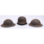 A German, Third Reich soldier's steel helmet and two contemporary British military steel helmets,