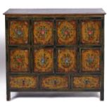 A Tibetan polychrome cabinet, 19th / 20th c, of typical panelled construction with an arrangement of