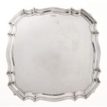 An Elizabeth II shaped square silver salver, the plain field in moulded border, on four scroll feet,