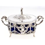 A French oval silver openwork butter dish and cover, c1900, the domed cover with putto finial, the