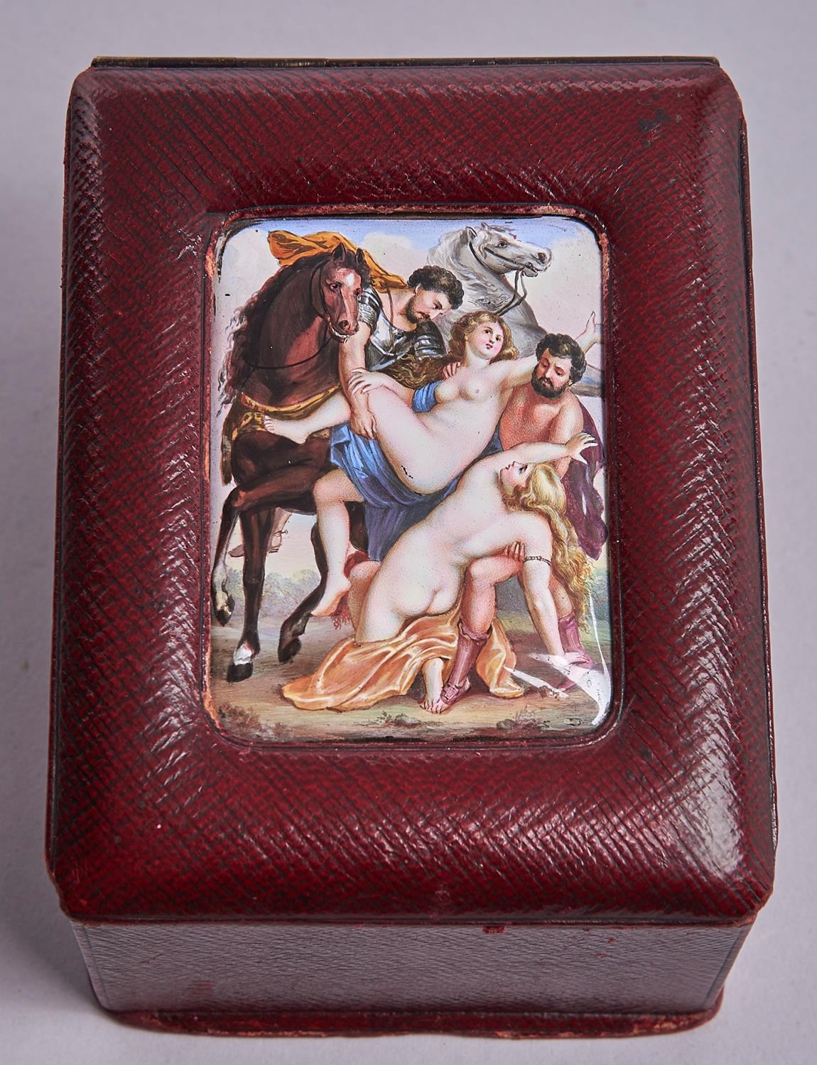A maroon leather box, c1900, the sloping lid inset with an enamel plaque of the Rape of the