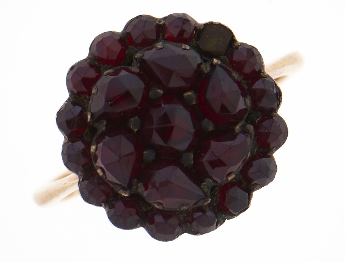 A garnet cluster ring, c1900, gold coloured metal hoop, 2.8g, size L One stone deficient, light wear