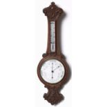 An Edwardian carved oak aneroid barometer, Lowe & Sons Chester, with mercury thermometer, 83cm h