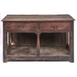 An oak dresser, 18th c, with boarded top and fitted two drawers, the brass handles apparently