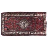 A Caucasian style red ground rug, 87 x 192cm Good condition but for requiring a clean