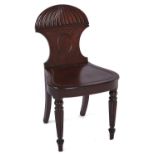 A George IV mahogany hall chair, the fan carved back centred by an oval blind medallion, having