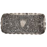A Victorian silver comb tray, die stamped with masks and foliage around a vacant cartouche, in