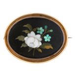 A pietre dure brooch, c1870, the oval plaque decorated with a prominent white flower, mounted in