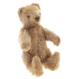 A miniature faded golden mohair teddy bear, 14cm h Feet slightly bent and worn