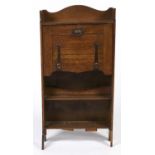 An Arts and Crafts oak bureau, c1900, with serpentine shaped three quarter gallery, the fall flap