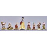 A set of Royal Doulton bone china or earthenware figures of Snow White and the Seven Dwarves, Snow