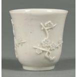 A Chinese blanc de chine beaker, Kangxi period, of inverted bell shape with three prunus sprigs,