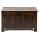 An oak chest, with boarded lid and three panel front on channelled stiles, 61cm h; 48 x 107cm An old
