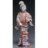 A Japanese Imari figure of a bijin, Meiji period, her kimono decorated with wisteria, bamboo and