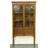 An Edwardian mahogany display cabinet, c1905,  the  flared cornice above a shallow frieze enclosed