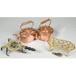 Two copper kettles and two brass trivets, 19th c